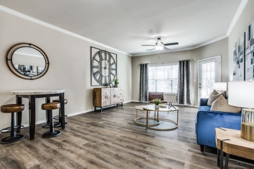 a living room with a large clock on the wall at Village of Hawks Creek Apartments, Westworth Village