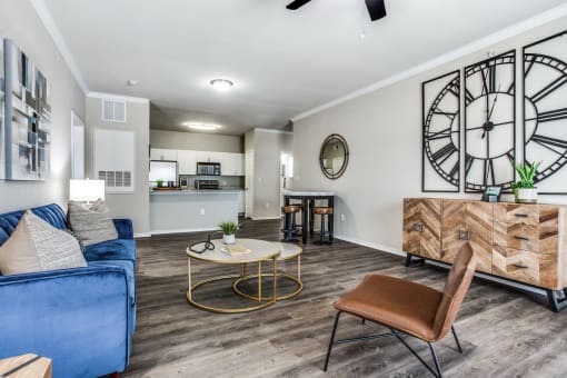 a living room with a large clock on the wall and a couch at Village of Hawks Creek Apartments, Westworth Village Texas