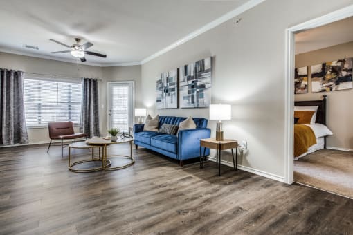 a living room with a couch and a ceiling fan at Village of Hawks Creek Apartments, Westworth Village, TX