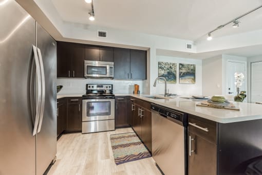 Open kitchen with stainless steel appliances and a counter top at The Atlantic at Tradition, Port St Lucie, Florida