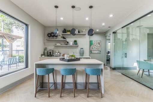 Kitchen with an island and three blue stools at The Atlantic Preserve, Plantation, FL