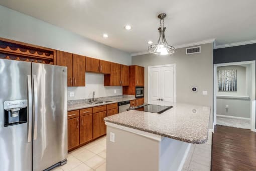 Kitchen with granite countertops and wooden cabinets at Vintage Park Apartments, Houston