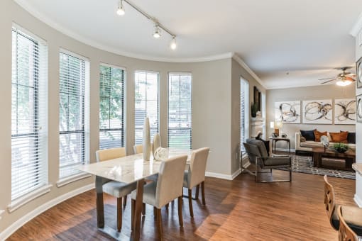 Dining room with a table and chairs and a living room with windows at Vintage Park Apartments, Houston, 77070