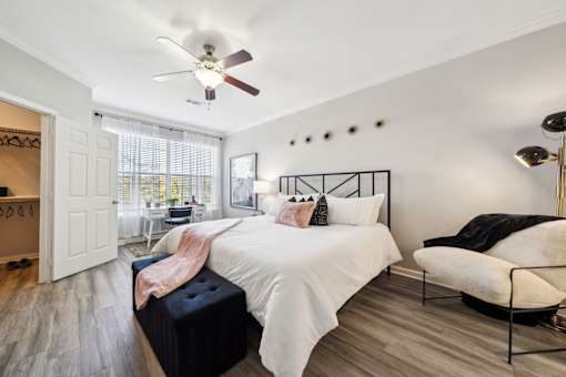 A bedroom with a white bed and a ceiling fan at The Atlantic Stone Oak Apartments, San Antonio