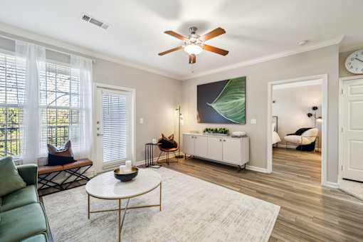 A living room with a ceiling fan and a painting on the wall at The Atlantic Stone Oak Apartments, San Antonio
