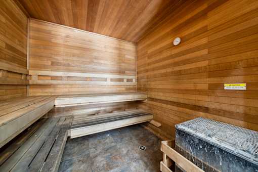 A sauna with wooden walls and benches at The Atlantic Stone Oak Apartments, San Antonio