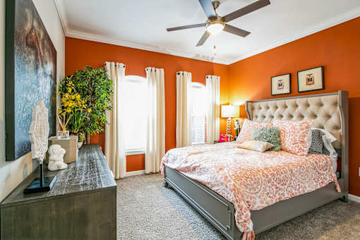 A bedroom with orange walls and a large bed at The Atlantic Buckhead Apartments, Atlanta, 30305