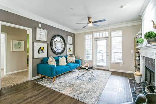 A living room with a blue couch and a rug at The Atlantic Buckhead Apartments, Georgia