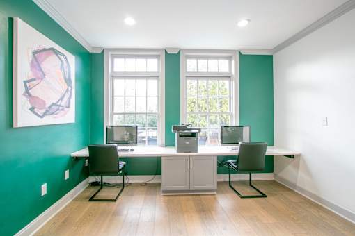 A room with green walls and a white desk with two chairs at The Atlantic Buckhead Apartments, Atlanta, 30305