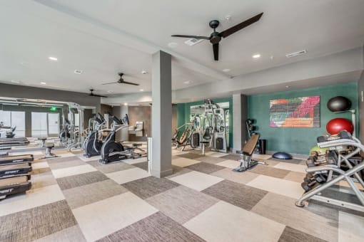 Gym with weights and cardio machines and a ceiling fan at The Atlantic Highland Park, Dallas, Texas