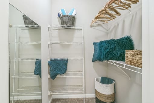 A white closet with shelves and baskets at The Atlantic North Highland, Charlotte
