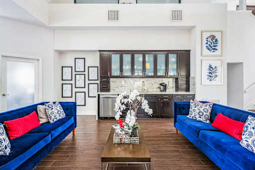 A living room with blue couches and a coffee table at Boca Colony Apartments, Boca Raton, Florida