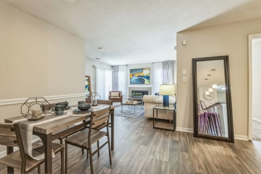an open living room and dining room with a table and chairs and a mirror at Magnolia Terrace Apartments, North Carolina 28213