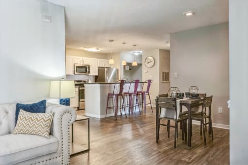 an open living room and kitchen with a dining room table and chairs at Magnolia Terrace Apartments, Charlotte, North Carolina