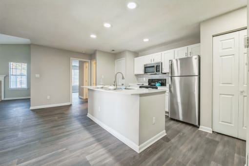 an empty kitchen with a large island and stainless steel refrigerator at Magnolia Terrace Apartments, Charlotte, NC