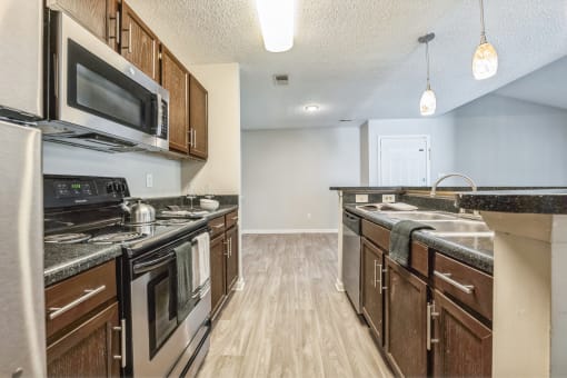 an open kitchen with stainless steel appliances and wooden cabinets at Magnolia Terrace Apartments, Charlotte, NC, 28213