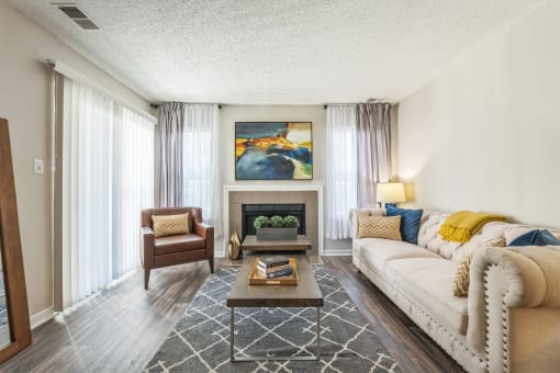 A living room with a fireplace and a painting on the wall at Magnolia Terrace Apartments, North Carolina
