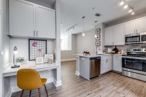 A kitchen with a yellow chair in the foreground.