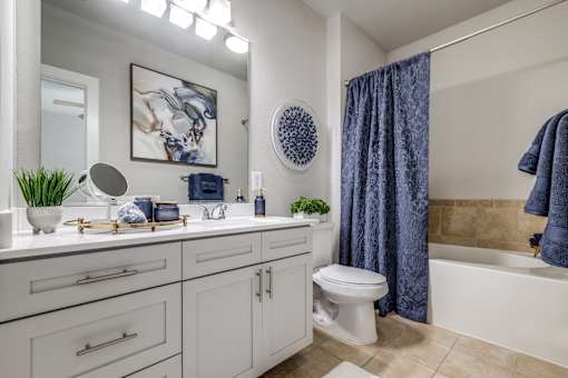 A bathroom with a white toilet and a blue shower curtain.