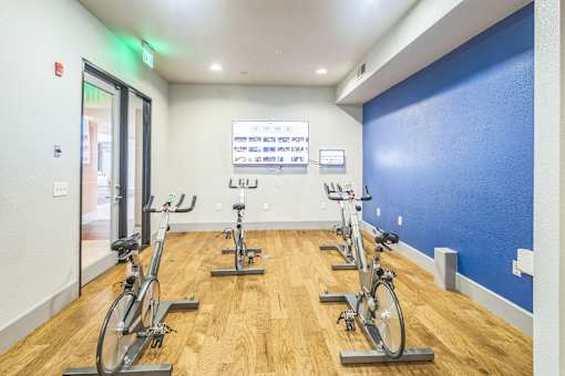 A gym with a row of stationary bikes and a sign on the wall  at The Atlantic Memorial, Houston