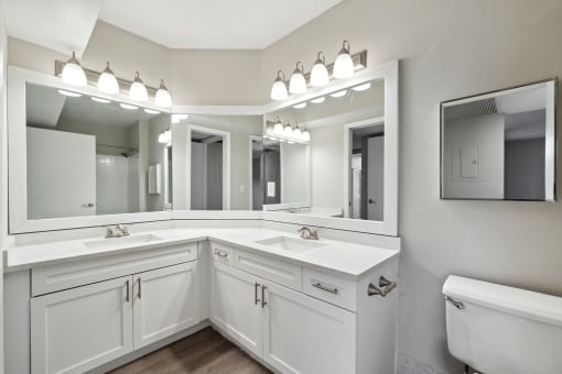 White bathroom with two sinks and a large mirror at The Atlantic Preserve, Plantation, FL 33322