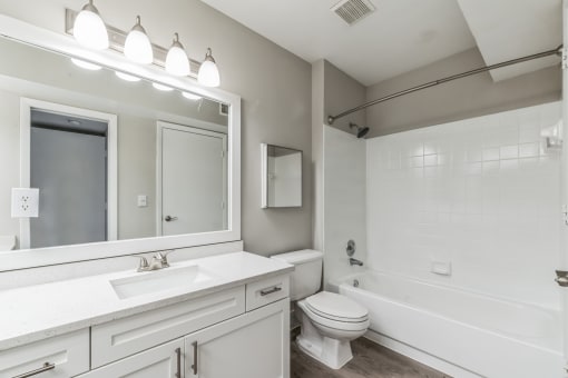 White bathroom with a large mirror and a white toilet at The Atlantic Preserve, Plantation