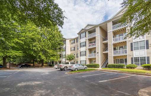 A parking lot in front of a multi-story apartment building.at The Atlantic Canton Ridge, Georgia  