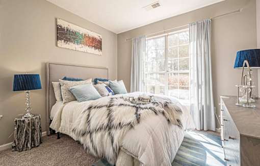 A bedroom with a large bed and a painting on the wall.at The Atlantic Canton Ridge, Canton  