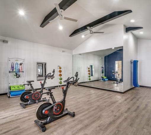 a group of exercise bikes in a room with a yoga studio and a mirror at Palazzo, San Marcos, Texas