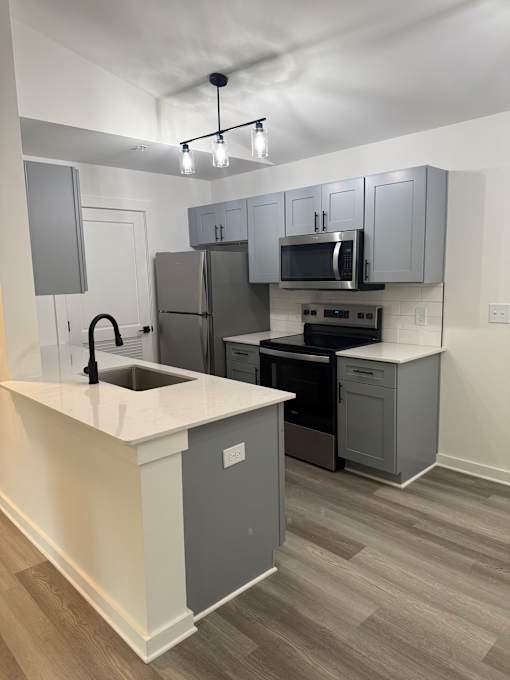 A modern kitchen with a staircase leading to the upper floor at The Atlantic Brookhaven, Georgia, 30329
