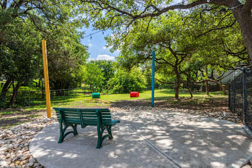 A park with a green bench and trees at Reserve at Canyon Creek, San Antonio, 78230