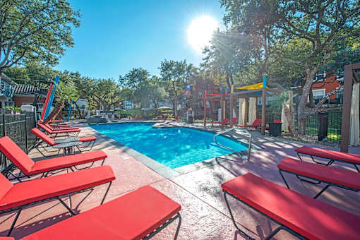 A sunny day at the pool with red sun loungers at Reserve at Canyon Creek, San Antonio,78230