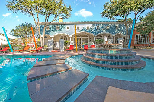 A pool with a water slide and a building in the background at Reserve at Canyon Creek, San Antonio,TX,78230