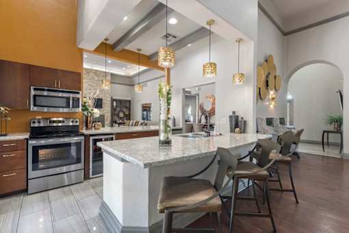 A modern kitchen with a large island and chairs at Reserve at Canyon Creek,San Antonio