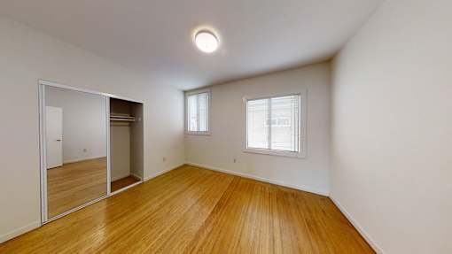 A room with wooden floors and a large mirror on the wall.