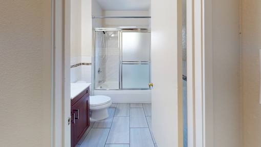 A bathroom with a toilet, sink, and shower.