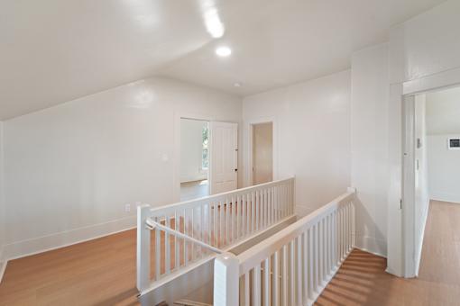 A white interior with a staircase and a door.