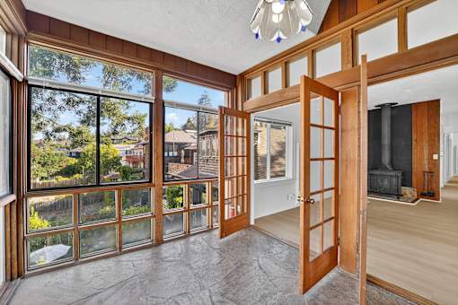 A room with a large window and a view of a backyard.