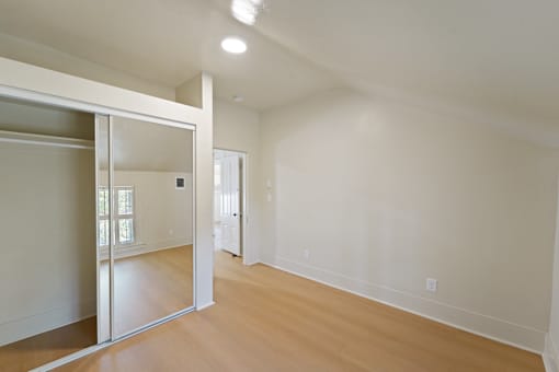 A room with a sliding door and wooden floors.