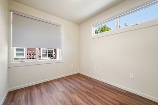 A room with a window and a wooden floor.