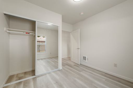 A white room with a sliding door and a white closet.