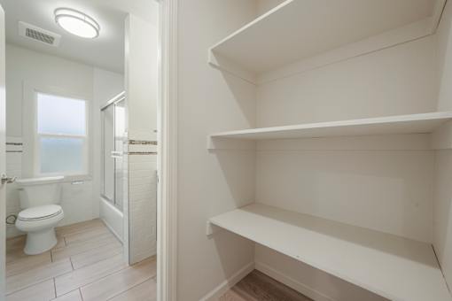 A white bathroom with a toilet and a walk in shower.