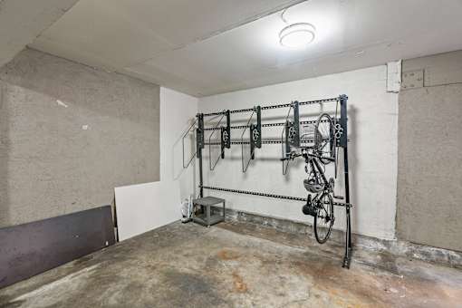 A bicycle rack with several bicycles hanging on it.