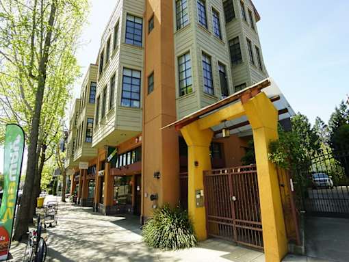 A yellow and brown building with a gate in front.