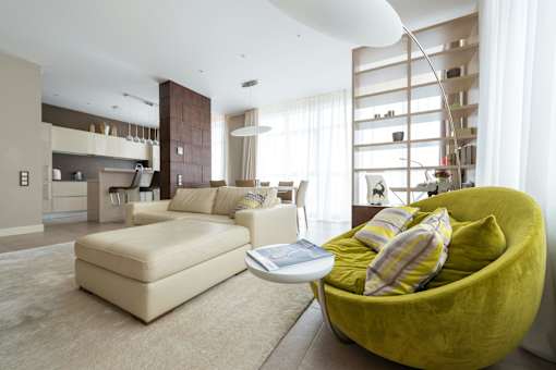 A modern living room with a green chair and a white couch.