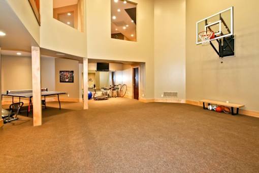 A basketball hoop is mounted on a wall in a spacious room.
