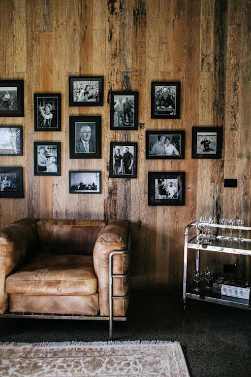 A leather sofa sits in front of a wall of framed photos.