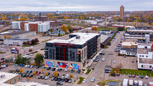 an aerial view of a city with a building and parking lot