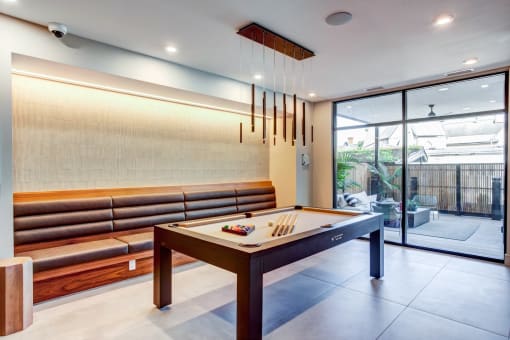 a billiards table in a living room with glass doors