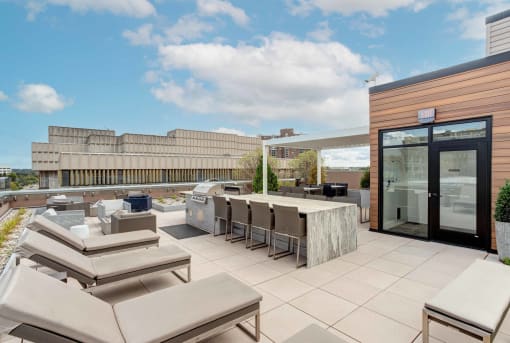 Studios in Kalamazoo, MI - 400 Rose - Rooftop with Sun Lounge Chairs, a BBQ Grilling Station, and a Large Granite Table